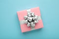 Pink gift box with silver bow on blue background Royalty Free Stock Photo