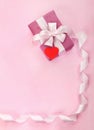 Pink gift box  white bow  long curved ribbon  paper red heart and empty space for text Royalty Free Stock Photo