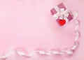 Pink gift box, white bow, long curved ribbon, paper red heart and empty space for text. Royalty Free Stock Photo