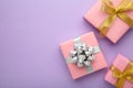 Pink gift boxes with silver and gold bow on purlpe background Royalty Free Stock Photo