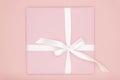 Pink gift or present box flat lay composition for Valentine day or women day, greeting card birthday with on coral background.