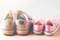 Pink girl sneakers and White man sneakers on a wooden floor