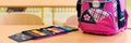 Pink girly school bag and pencil case on a desk in an empty classroom. First day of school concept. Royalty Free Stock Photo