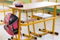 Pink girly school bag and pencil case on a desk in an empty classroom. First day of school. Royalty Free Stock Photo