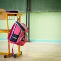 Pink girly school bag and pencil case on a desk in an empty classroom. First day of school. Royalty Free Stock Photo