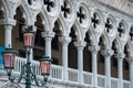 Pink glassed lamppost before the loggia of the Doge`s Palace in Venice, Italy