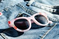 Pink  glasses on a pair of blue jeans  pants Royalty Free Stock Photo