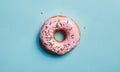 Pink glazed donut with sprinkles on blue background Royalty Free Stock Photo