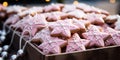 Pink glazed gingerbread cookies decorated like small stars. Pink Christmas banner and bokeh lights