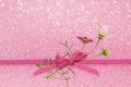 Pink glitter background with ribbon bow and cosmos flowers Royalty Free Stock Photo