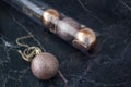 A pink glittered Christmas ball on a dark marble background. on the background box with toys in pink and bronze colores