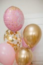 Pink and golden balloons with text `it`s a girl` gender reveal party.