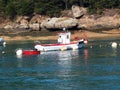 Pink granite coast and fishing boat.