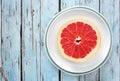 Pink grapefruit half with rustic blue wood background