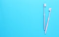 Pink and gray toothbrushes on blue background. Taking care of teeth, dental concept. Flat lay photo, copy space, top view