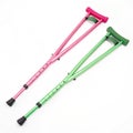 Pink and green crutches isolated on white background Royalty Free Stock Photo