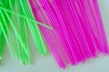 Pink and green drinking straws in rows