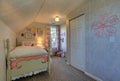 Pink and green girl`s attic bedroom with sloped ceiling