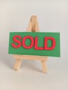 Pink and green sold sign on a wood easel on a white background Royalty Free Stock Photo