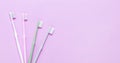 Pink, green, white and gray toothbrushes on purple background. Taking care of teeth, dental concept. Flat lay photo, copy space,