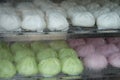 Pink green and white steamed stuff bun in hot stream container