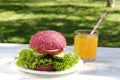 Pink hamburger and orange juice Royalty Free Stock Photo