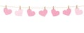 Pink hanging hearts on a rope on white background