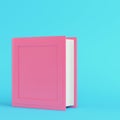 Pink hard covered book on bright blue background in pastel colors. Minimalism concept