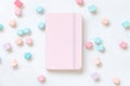 Pink hardcover notebook near pastel geometric decor on white table top view, textbook mockup