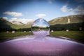 Pink hay-balls under a deep blue sky seen through a crystal ball. Royalty Free Stock Photo