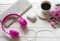 Pink Headphones and coffee cup on wooden desk table with pink flower. Music and lifestyle concept. Top view