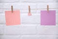 A pink heart is hung on a rope with sheets of paper with clothespins on a white background. Royalty Free Stock Photo