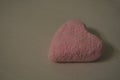 Pink heart made of airy plasticine on a white board