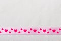 Pink heart ribbon on cloth background