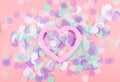 Pink heart on scattered colorful confetti