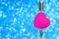 Pink heart shape penetrated by a steel bow arrow
