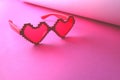 Pink heart-shaped glasses on a pink background. Valentine& x27;s Day.