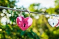 The pink heart shaped love padlock is hanging on wire in blur background Royalty Free Stock Photo