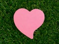 Pink heart-shaped notpad on the artificial grass Royalty Free Stock Photo
