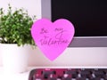 Pink heart shaped paper note with words Be My Valentine on it sticked on to a monitor at an office workplace Royalty Free Stock Photo