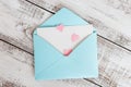 Pink hearts fly out of craft paper envelope on the light wooden background. Valentine day. Love concept Royalty Free Stock Photo