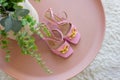 Pink heeled sandals lie on a pink table and beige rug. Stylish summer women shoes. Trendy beauty female fashion top view Royalty Free Stock Photo