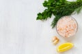 Pink Himalayan salt on the glass bowl, greens, piece of yellow lemon and fresh garlic Royalty Free Stock Photo