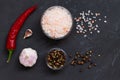 Pink Himalayan salt and mix of peppers in a glasses bowls on the black background. Royalty Free Stock Photo