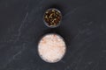 Pink Himalayan salt and mix of peppers in a glasses bowls on the black background. Royalty Free Stock Photo