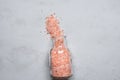 Pink Himalayan Salt in Vintage Glass Bottle Spilled on Grey Stone Tabletop. Wellness Spa Healthy Diet Nutrition Ayurveda Concept