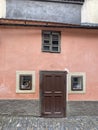 Pink historic small house with brown wooden windows and door in Golden Lane