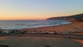 Pink horizon beautiful ocean with calm waves rolling on shore. Aerial view road Royalty Free Stock Photo