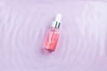 Pink hyaluronic acid serum for face with rose oils in water, top view. Regenerating, hydrating, revitalizing, detoxifying rose oil