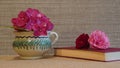 Hydrangea in a vase, roses and book on beige background with copy space